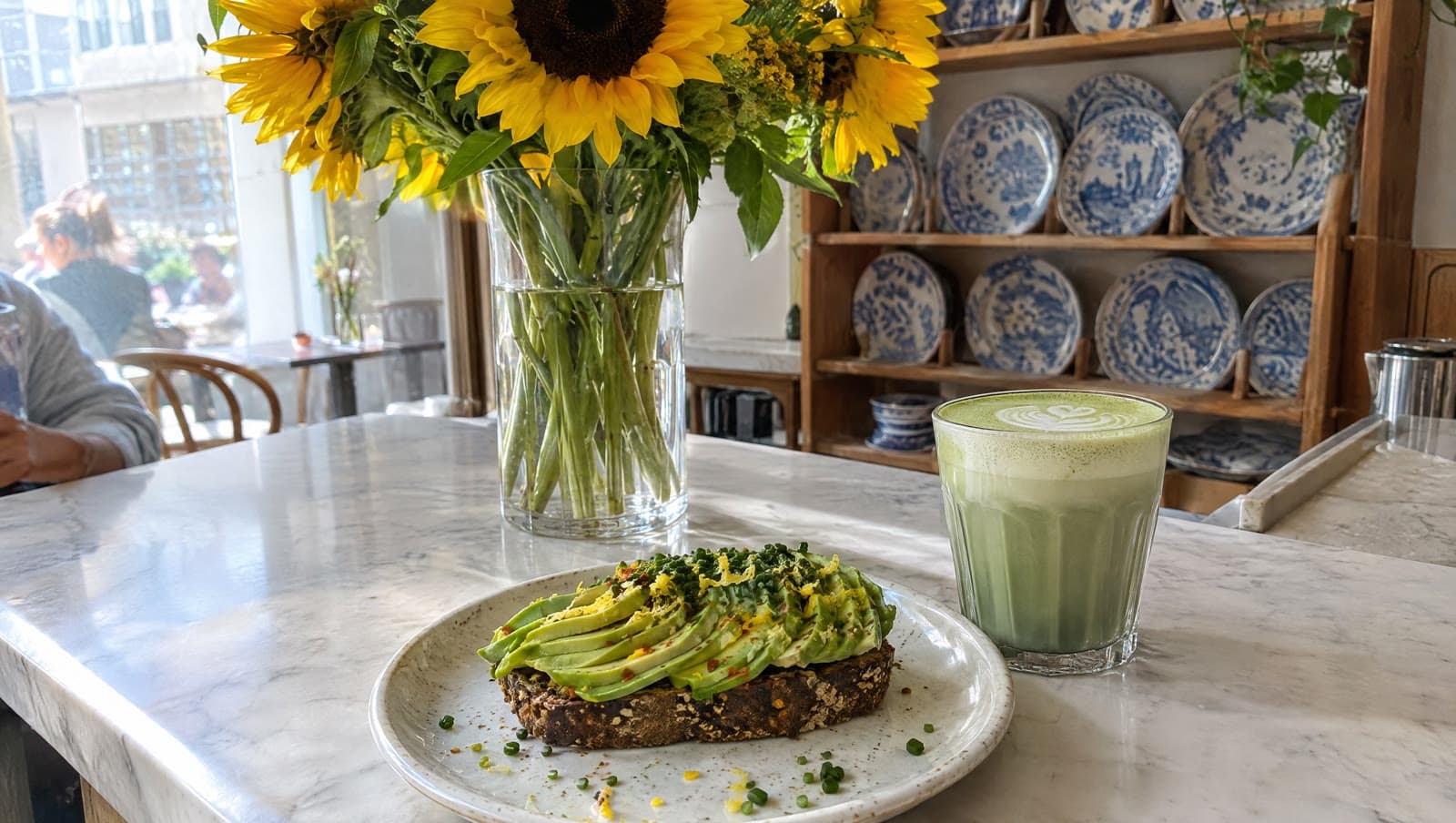 Avocado på rugbrød og solsikker på marmordisken — Atelier September