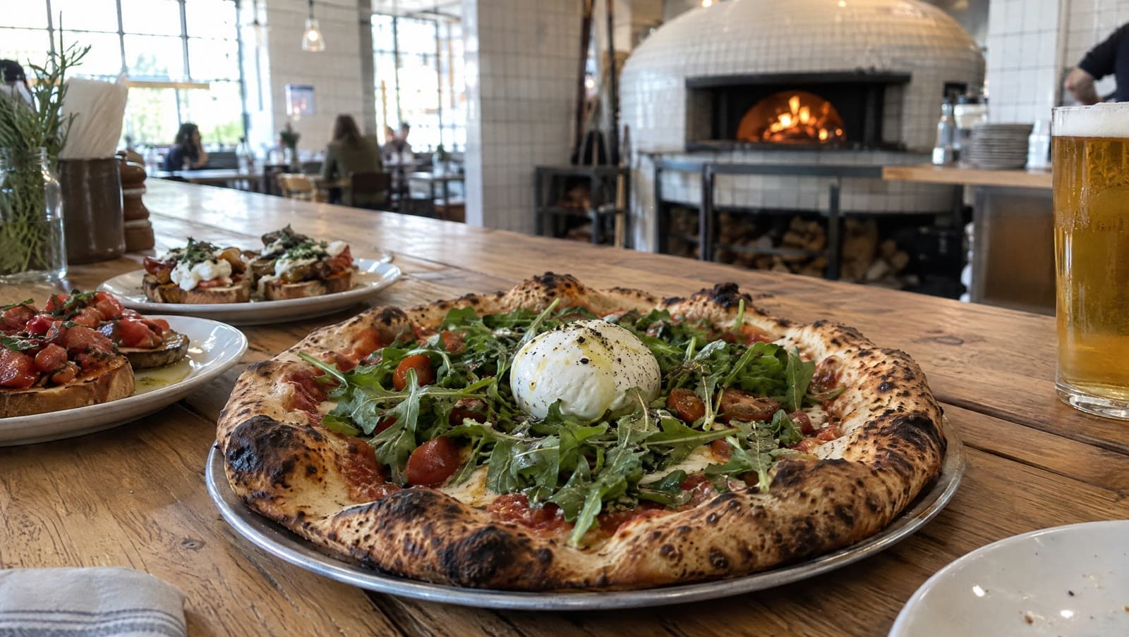 Surdejspizza med burrata og rucola på langbordet — Mother