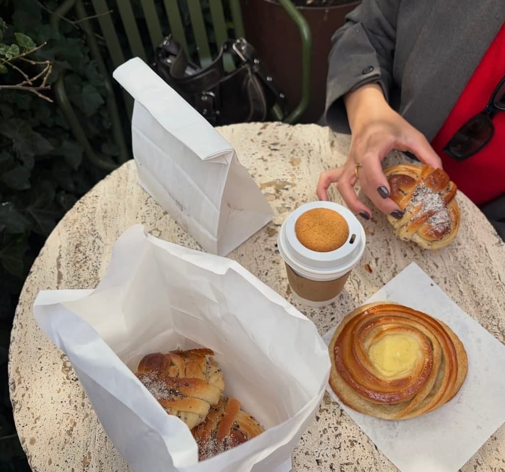 Kardemommesnurrer i papirposer på et cafébord — Juno the Bakery